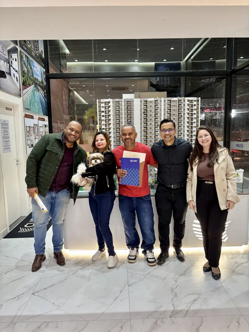 Grupo reunido em estande de atendimento imobiliário